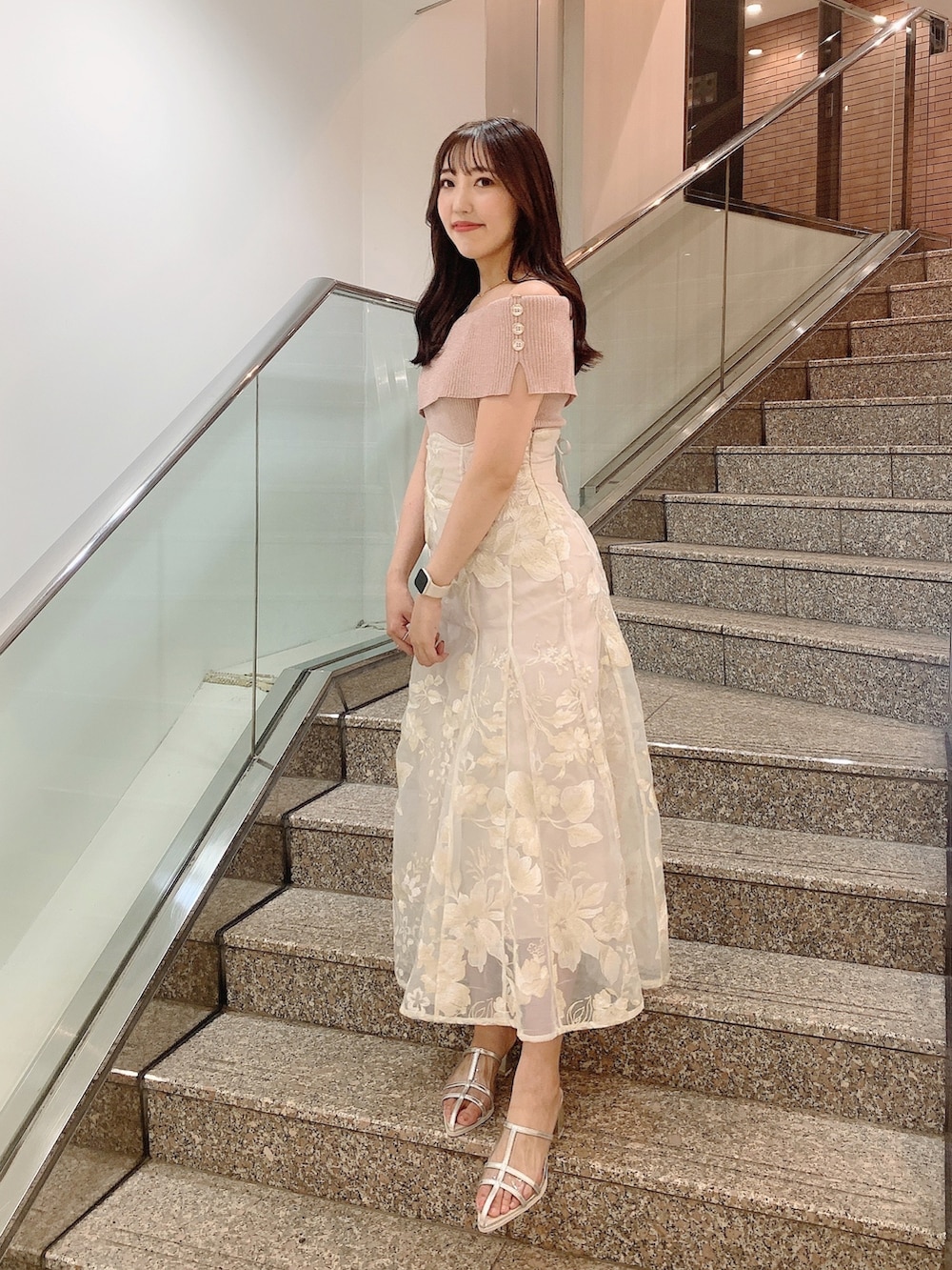 ベージュ系のスカート、ピンク系のニット/セーター、シルバー系のパンプスを着用したレディースの夏コーディネートの3枚目の写真