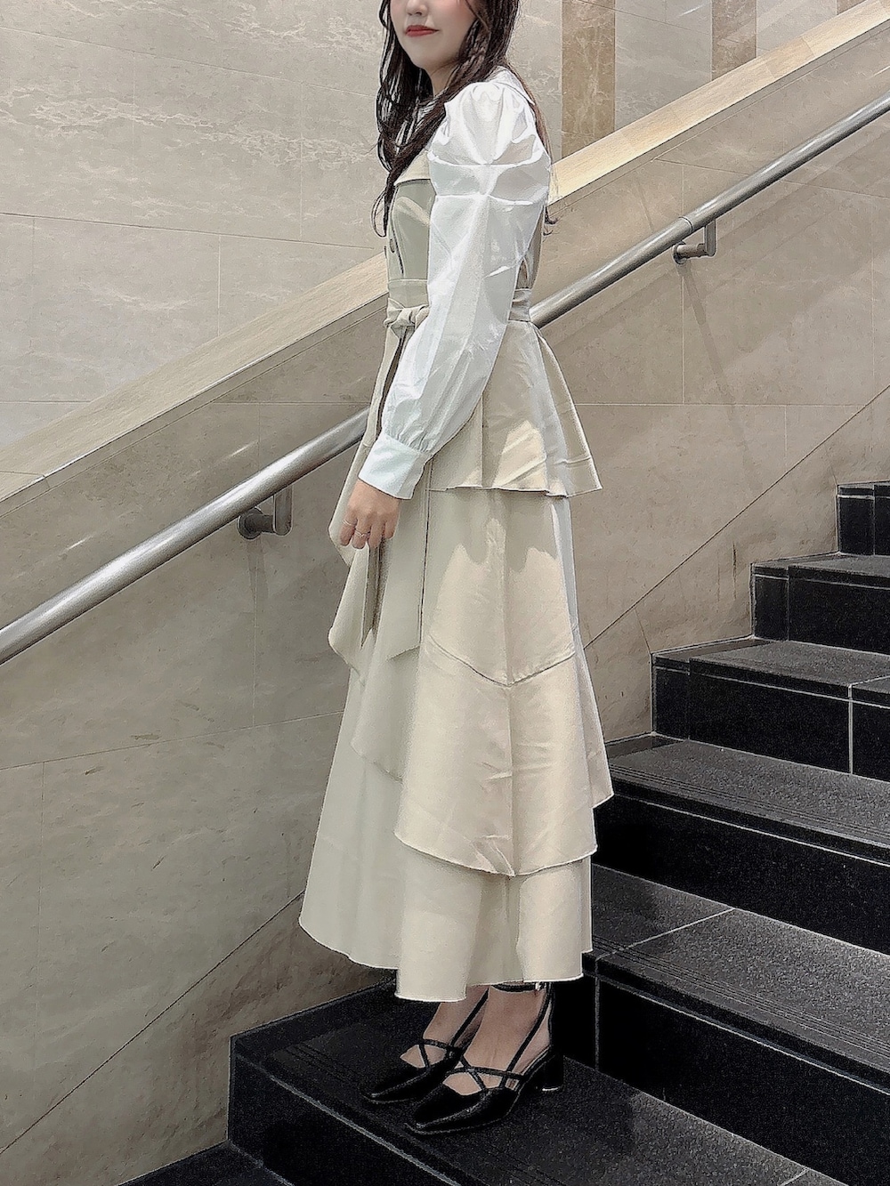 ベージュ系のワンピース、ブラック系のサンダルを着用したレディースの冬コーディネートの3枚目の写真