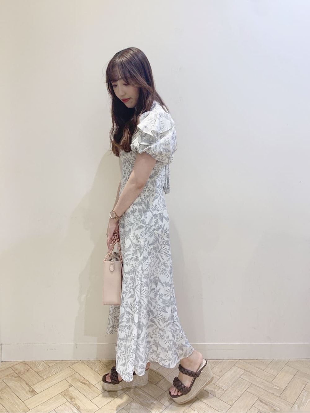 ホワイト系のワンピース、ブラウン系のサンダルを着用したレディースの春コーディネートの2枚目の写真