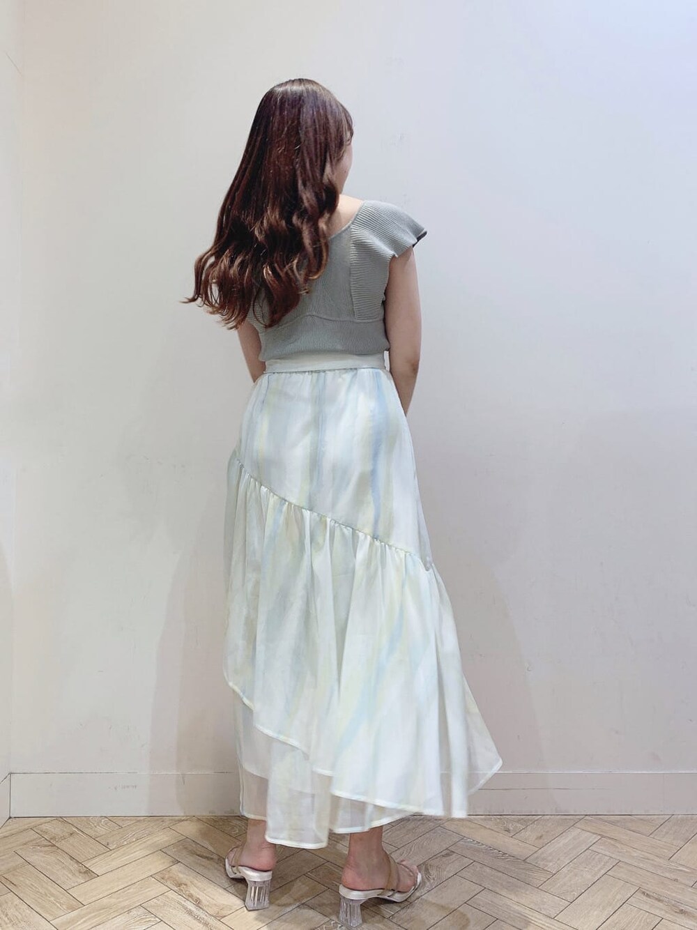 グリーン系のスカート、ベージュ系のサンダル、グリーン系のニット/セーターを着用したレディースの春コーディネートの5枚目の写真