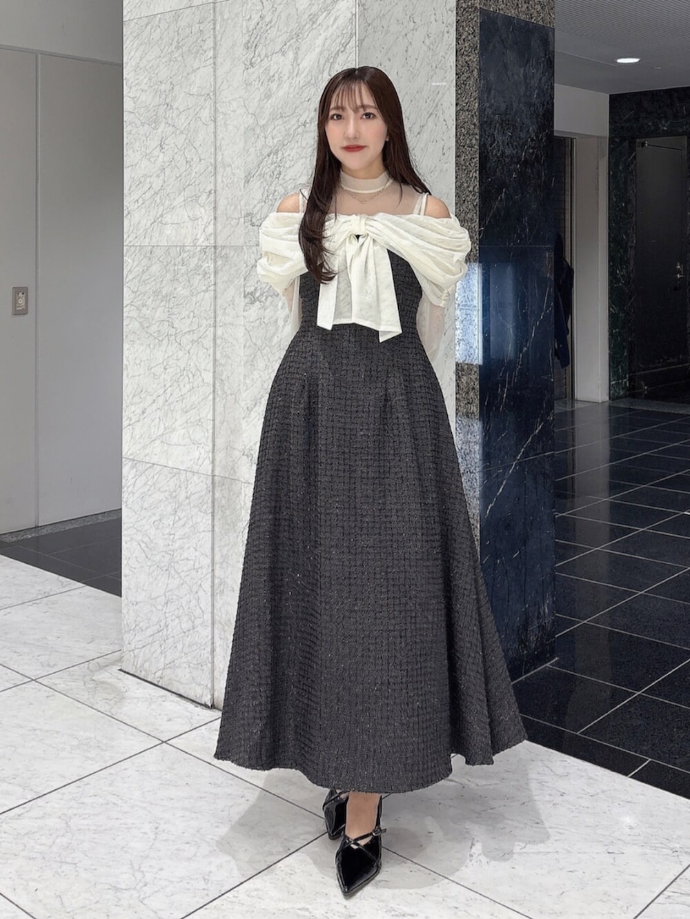 ブラック系のパンプス、ブラック系のドレスを着用したレディースの冬コーディネートの5枚目の写真