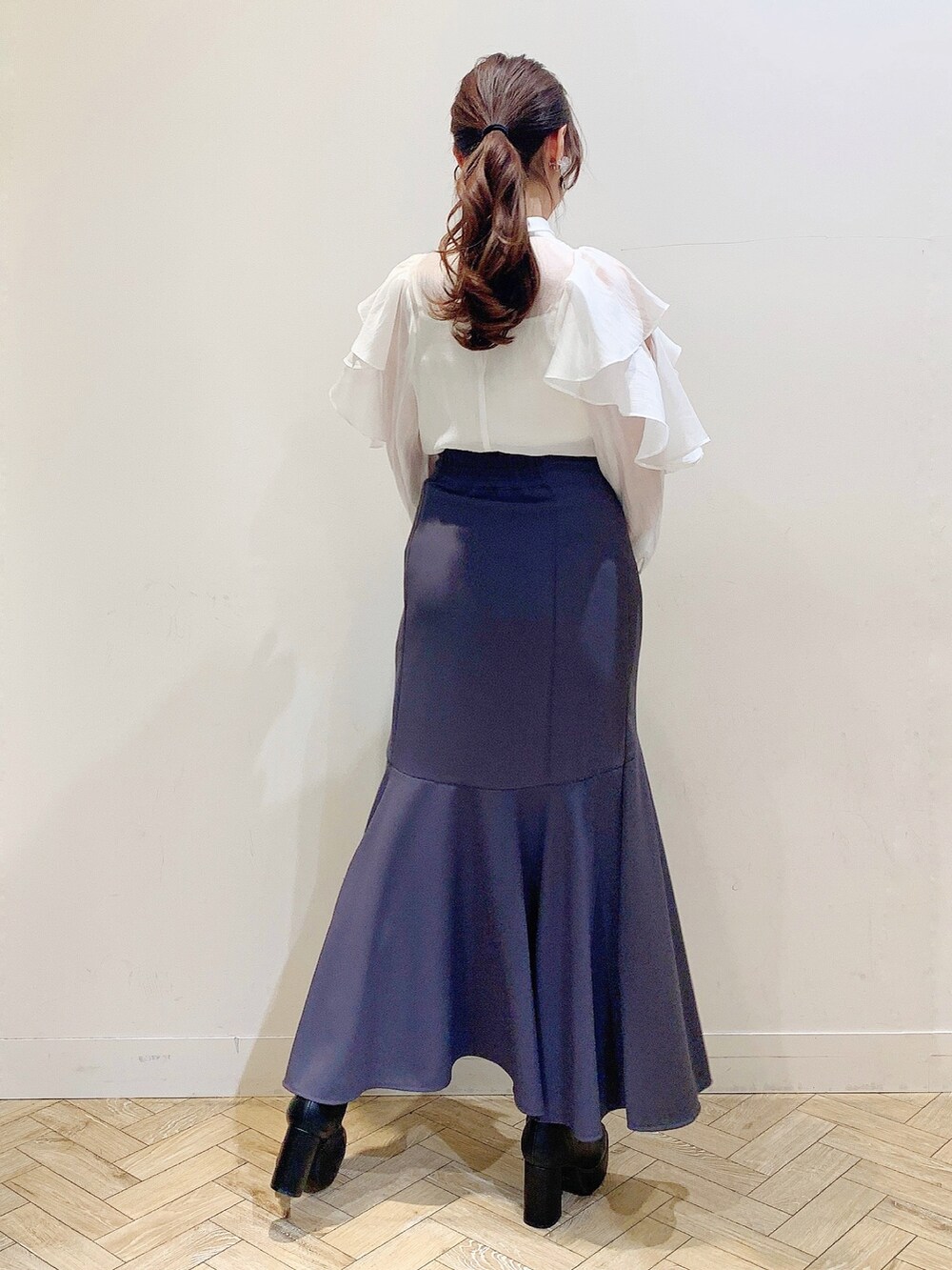 ホワイト系のシャツ/ブラウス、グレー系のスカート、ブルー系のハンドバッグを着用したレディースの冬コーディネートの6枚目の写真