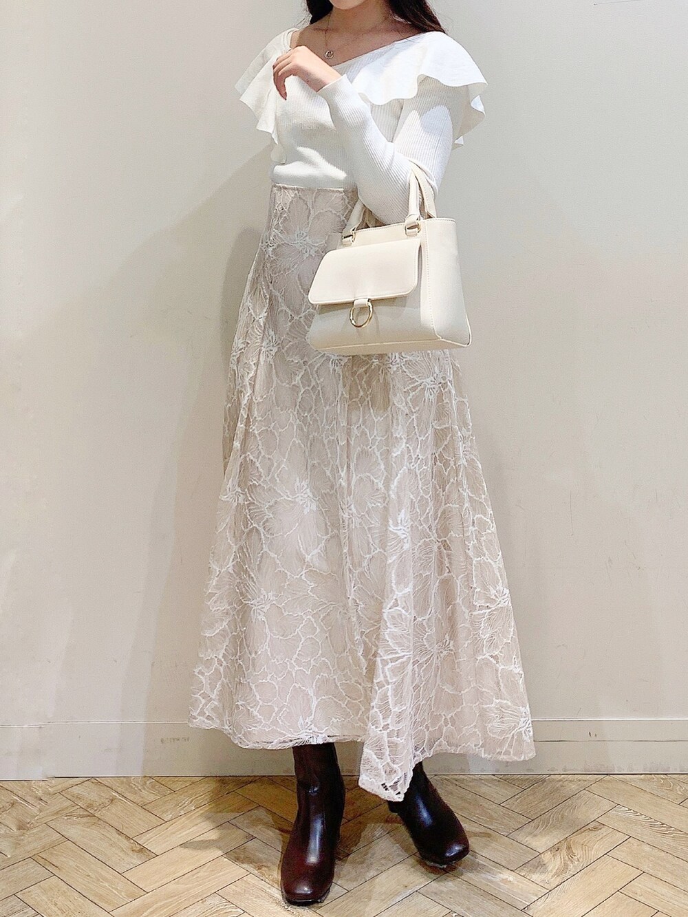 ベージュ系のスカート、ブラウン系のブーツ、ホワイト系のニット/セーターを着用したレディースの冬コーディネートの5枚目の写真