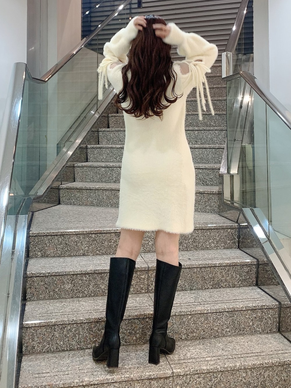 ブラック系のブーツ、ホワイト系のワンピースを着用したレディースの冬コーディネートの5枚目の写真