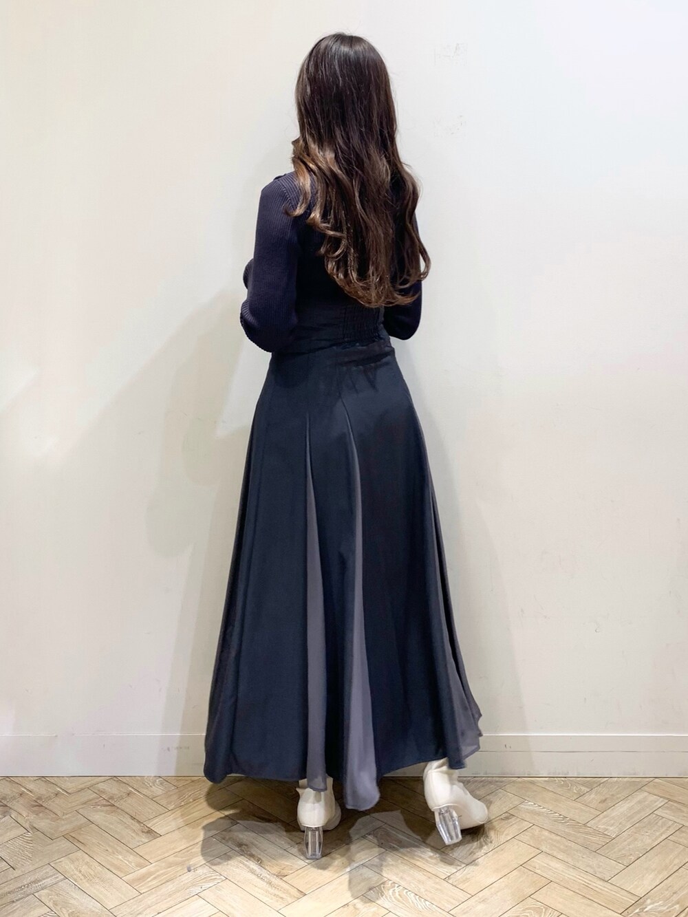 グレー系のニット/セーター、グレー系のスカート、ホワイト系のブーツを着用したレディースの冬コーディネートの5枚目の写真