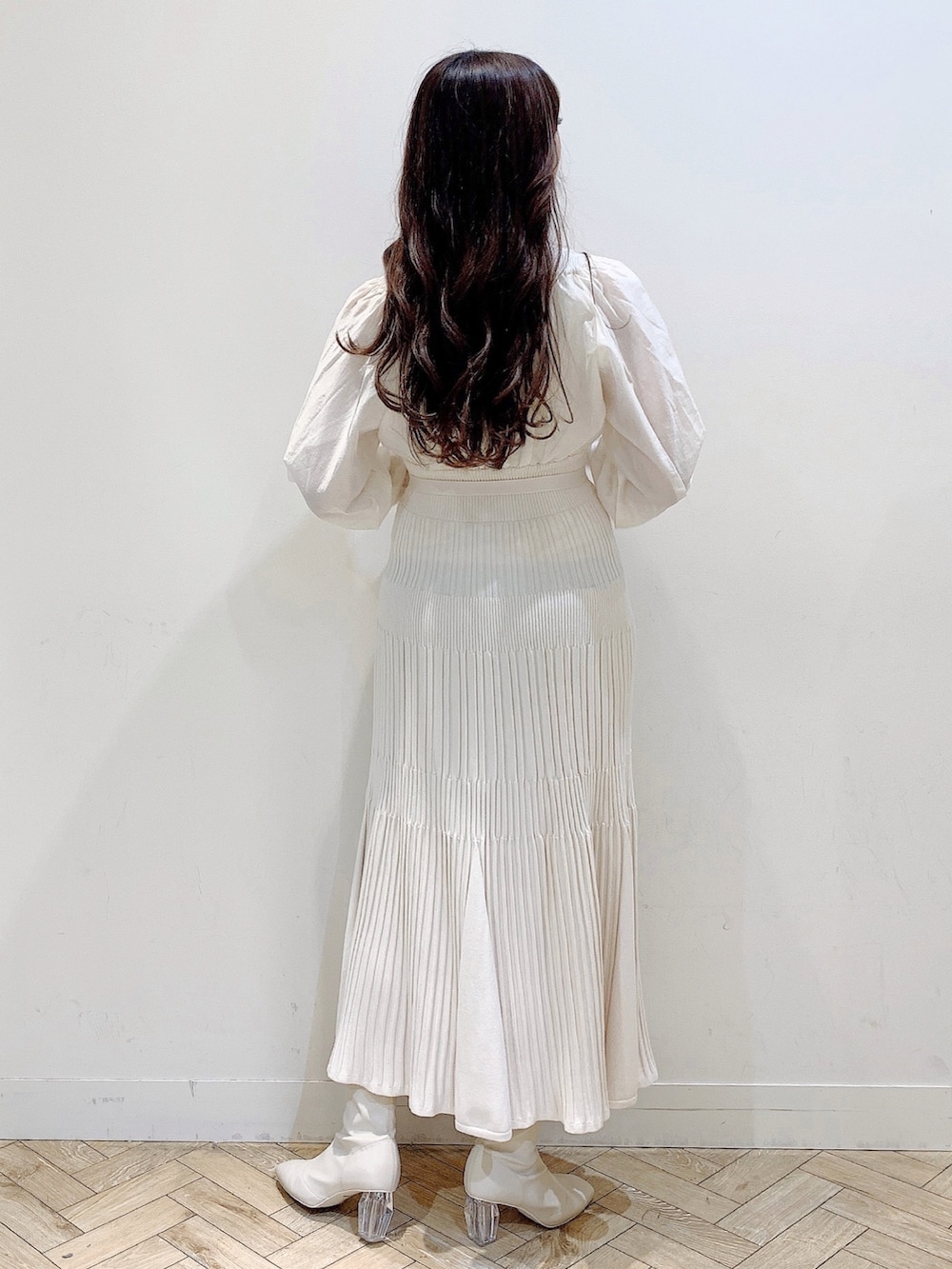 ホワイト系のワンピース、ブラウン系のチェスターコート、ホワイト系のブーツを着用したレディースの冬コーディネートの5枚目の写真