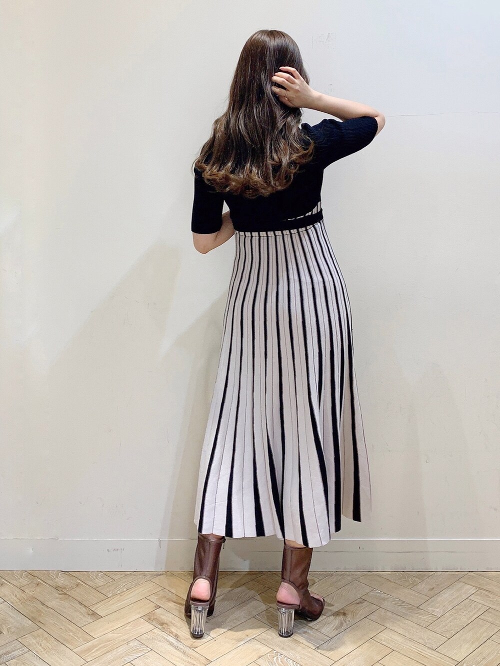 ブラック系のワンピース、ブラウン系のブーツを着用したレディースの春コーディネートの8枚目の写真