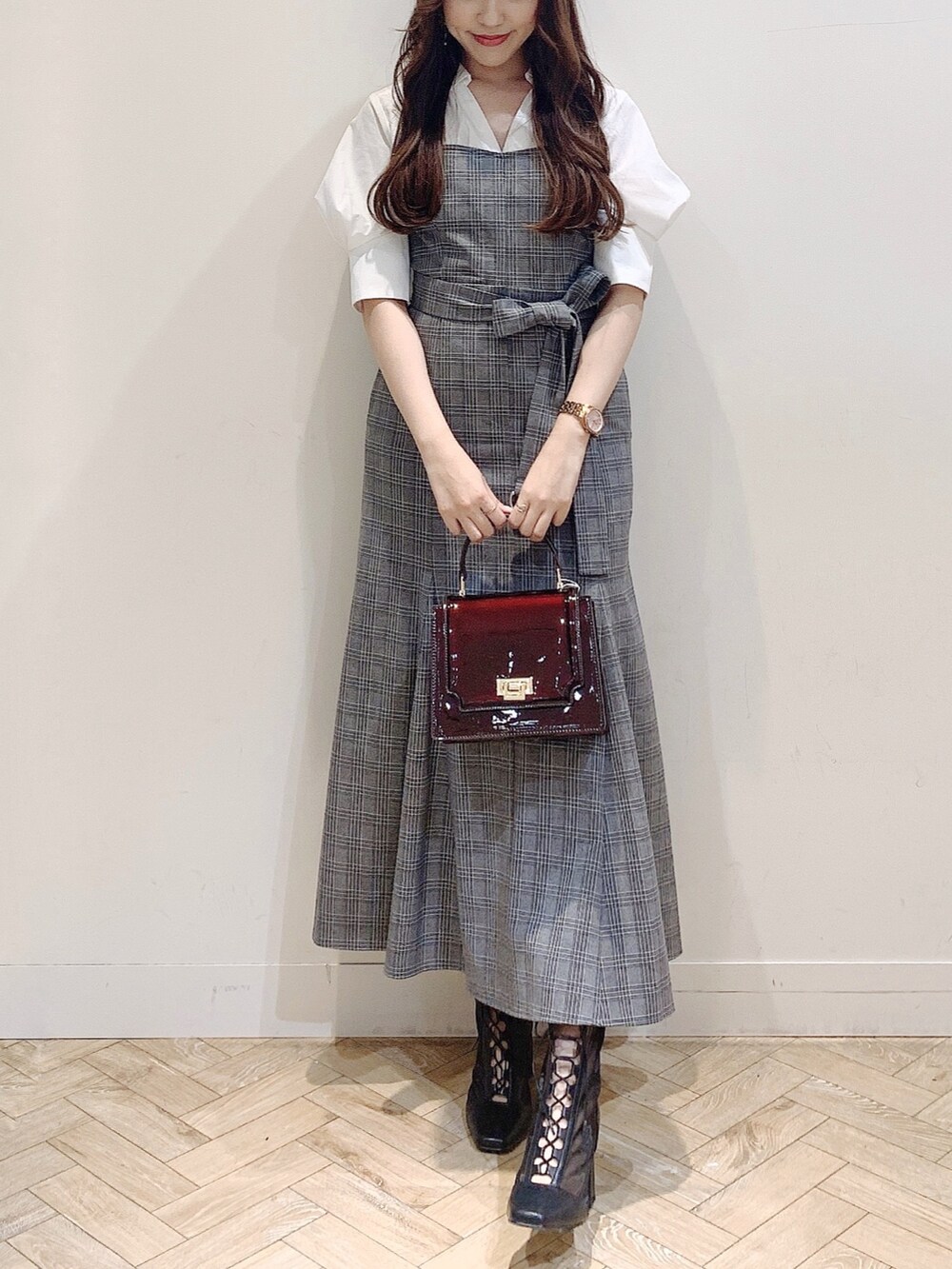 その他のワンピース、ブラウン系のハンドバッグ、ブラック系のブーツを着用したレディースの夏コーディネートの2枚目の写真