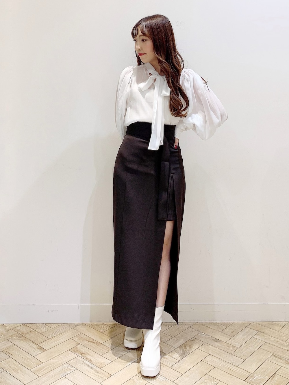 ブラウン系のスカート、ホワイト系のブーツ、ホワイト系のシャツ/ブラウスを着用したレディースの秋コーディネートの6枚目の写真