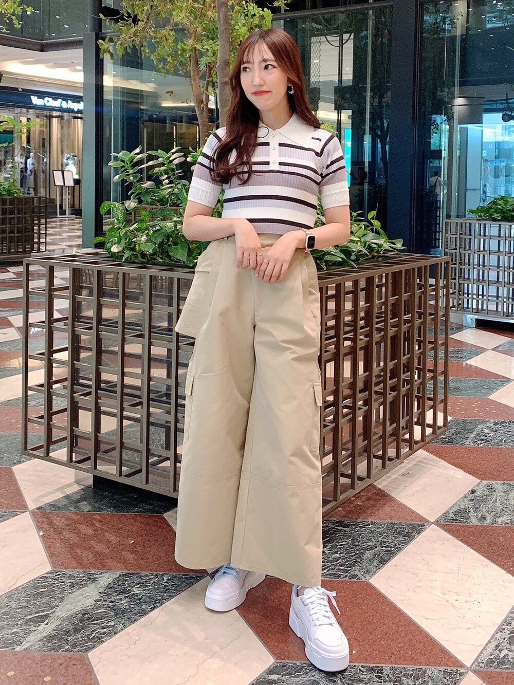 ベージュ系のチノパンツ、グレー系のニット/セーターを着用したレディースの春コーディネートの3枚目の写真