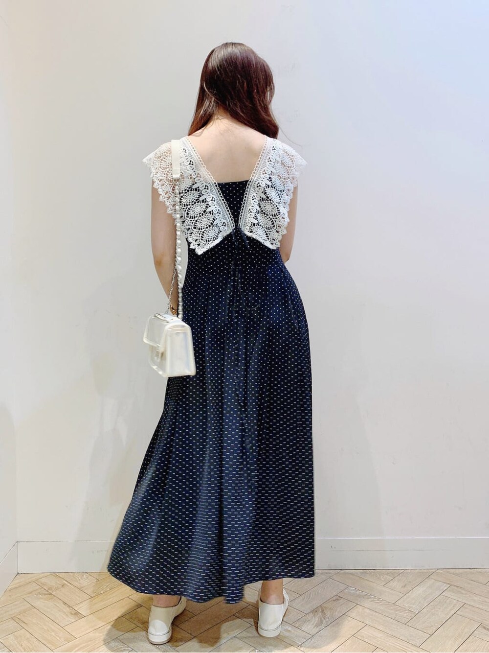 ホワイト系のパンプス、ブラック系のワンピース、ホワイト系のショルダーバッグを着用したレディースの春コーディネートの5枚目の写真