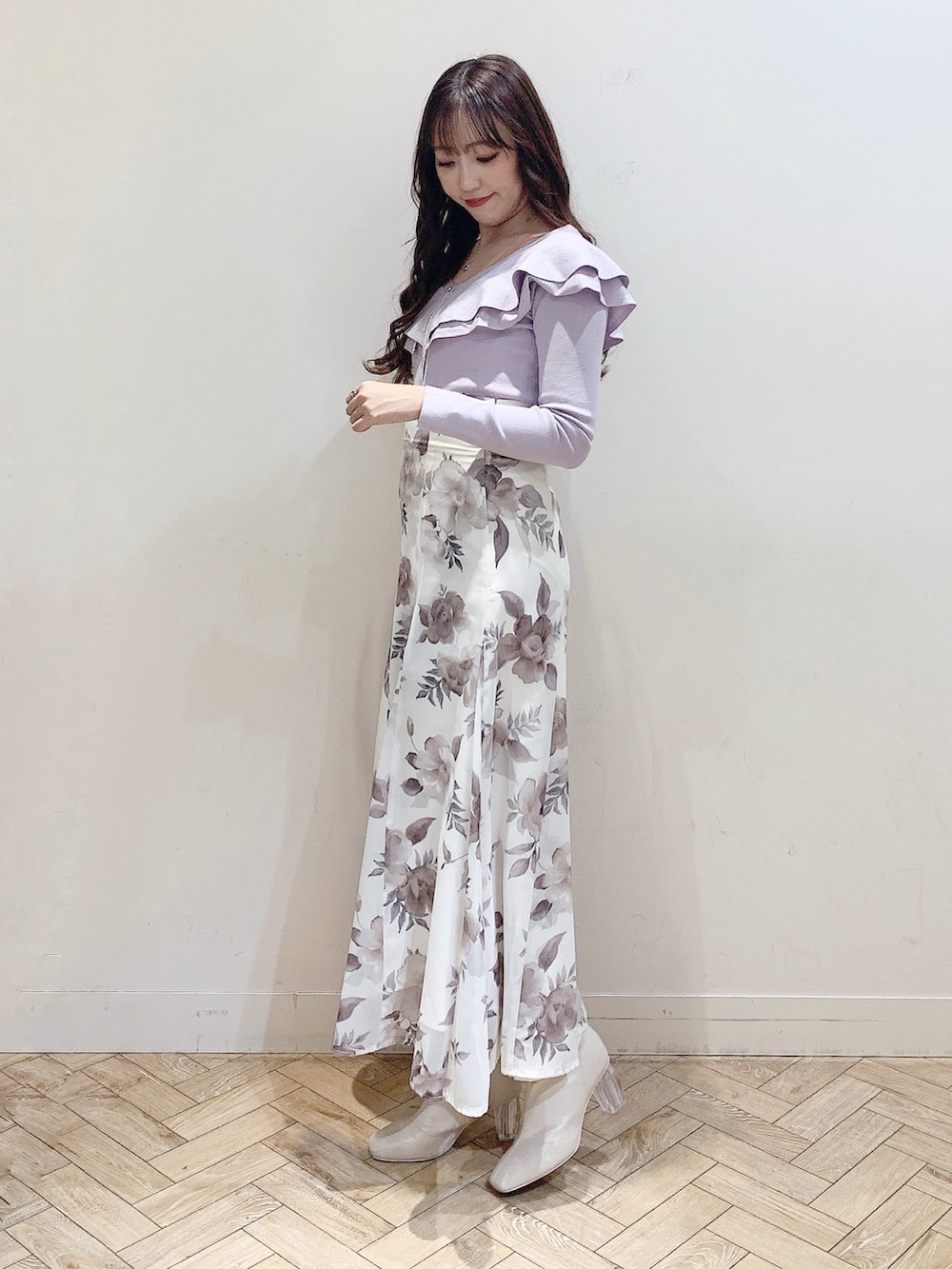 パープル系のニット/セーター、ホワイト系のスカート、ホワイト系のブーツを着用したレディースの冬コーディネートの3枚目の写真