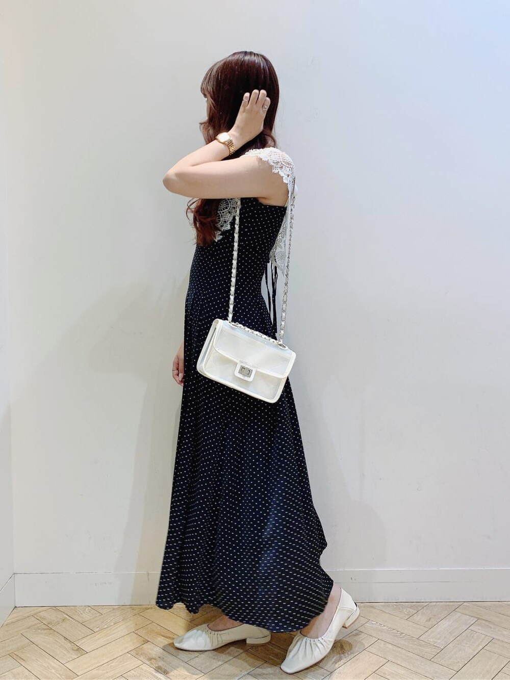 ホワイト系のパンプス、ブラック系のワンピース、ホワイト系のショルダーバッグを着用したレディースの春コーディネートの4枚目の写真