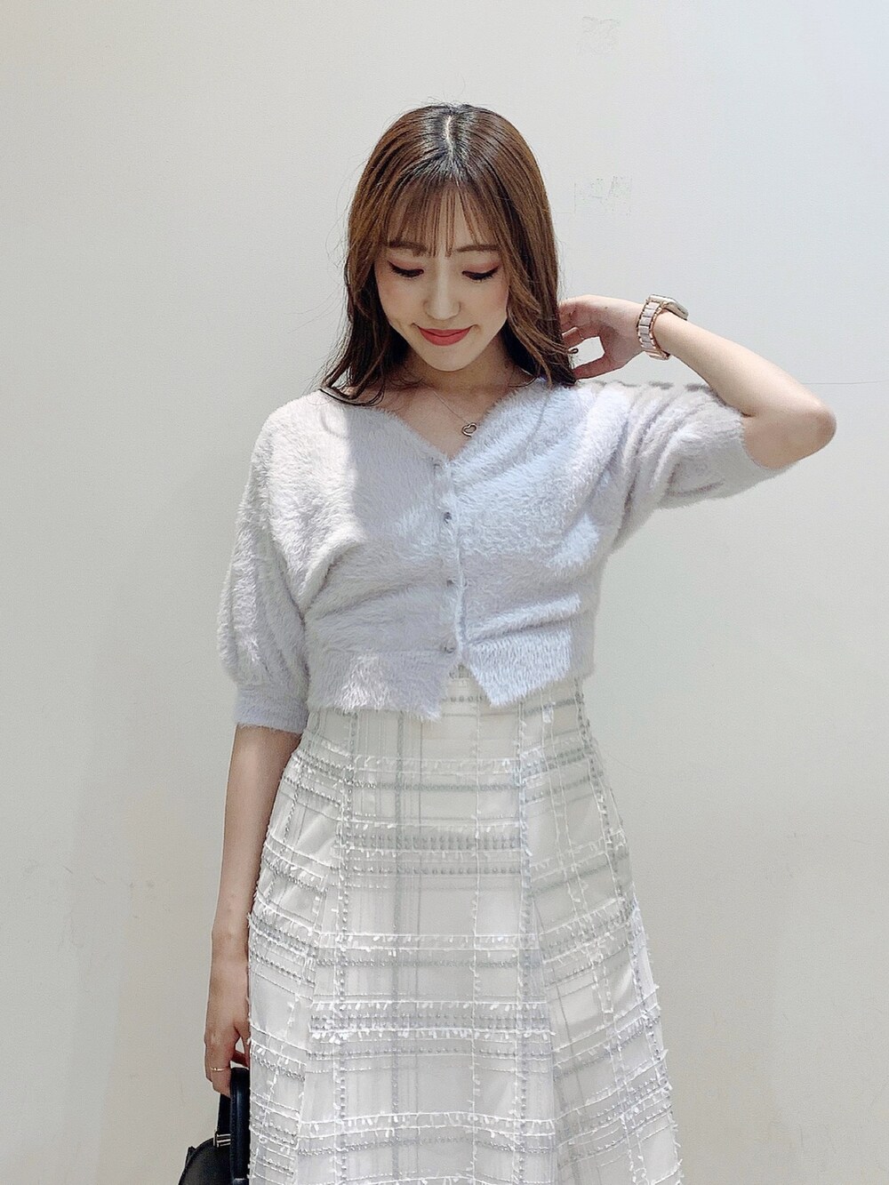 パープル系のカーディガン/ボレロ、ブラック系のスカート、ブラック系のパンプスを着用したレディースの夏コーディネートの8枚目の写真