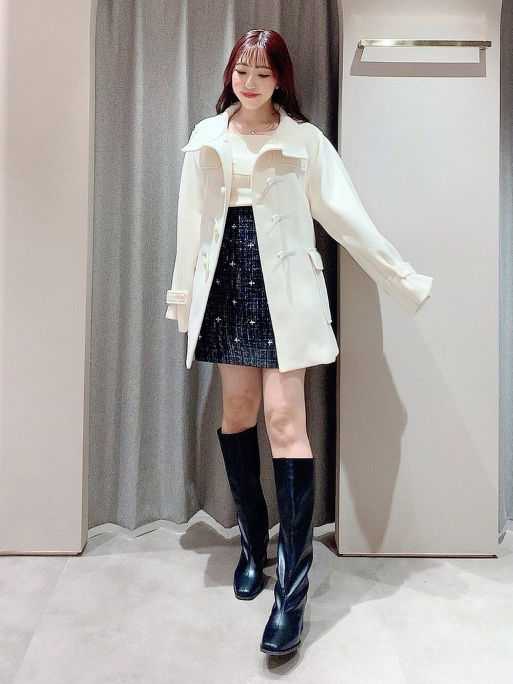 ホワイト系のダッフルコート、ホワイト系のニット/セーター、ブラック系のスカートを着用したレディースの秋コーディネートの7枚目の写真