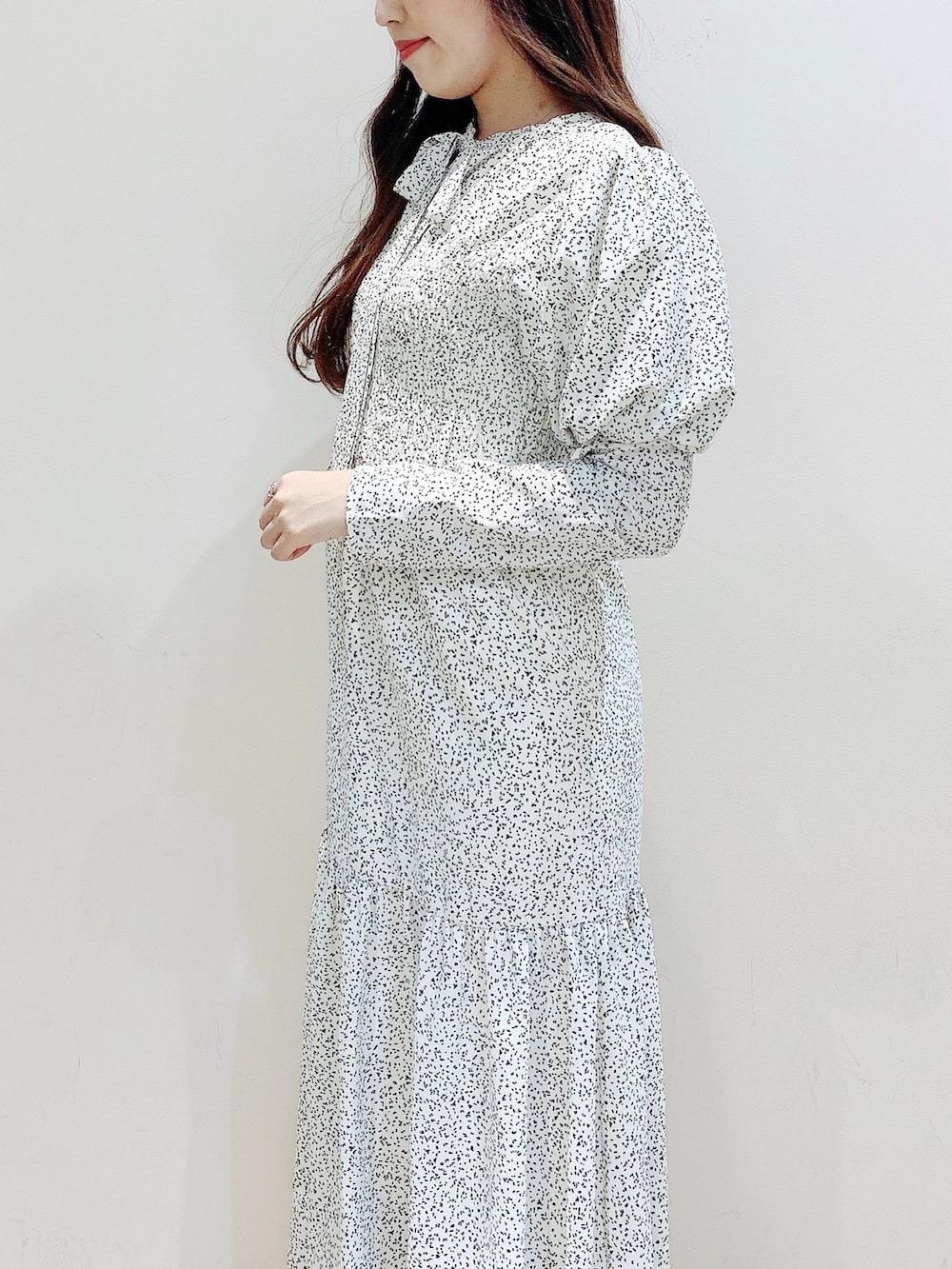 ホワイト系のワンピース、ブラウン系のダウンジャケット/コート、ホワイト系のブーツを着用したレディースの冬コーディネートの9枚目の写真