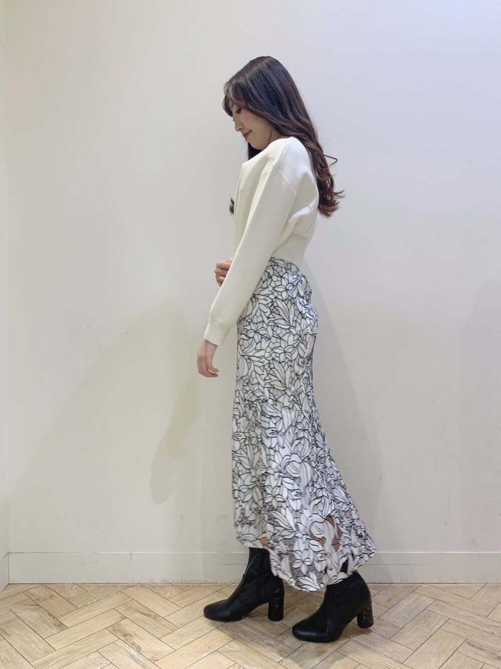 ブルー系のテーラードジャケット、ホワイト系のニット/セーター、ブラック系のワンピースを着用したレディースの春コーディネートの2枚目の写真