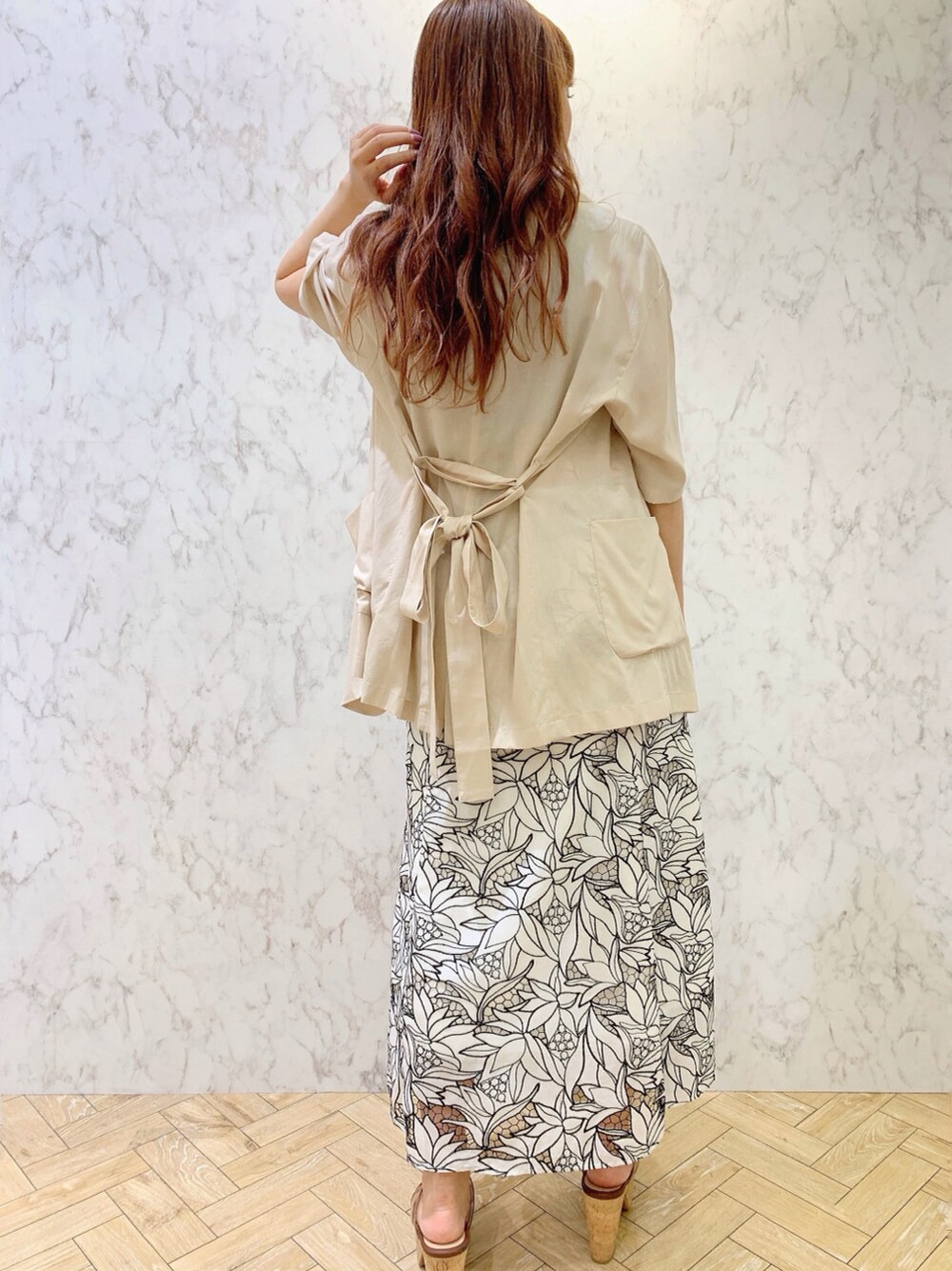 ブラック系のワンピース、ベージュ系のサンダル、ベージュ系のテーラードジャケットを着用したレディースの春コーディネートの2枚目の写真