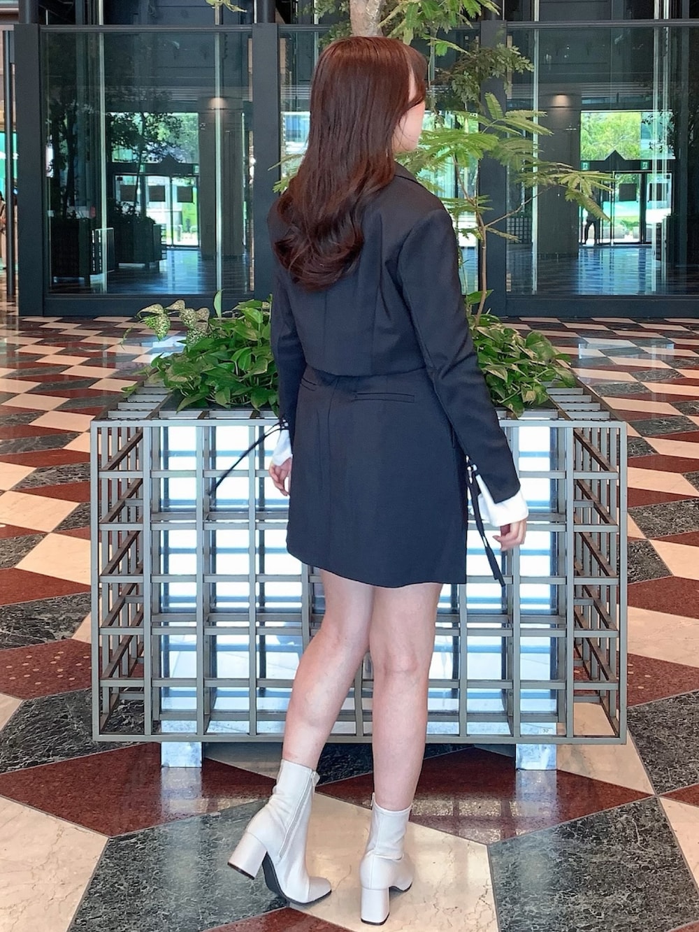 ブラック系のスカート、ブラック系のテーラードジャケット、ベージュ系のブーツを着用したレディースの秋コーディネートの8枚目の写真