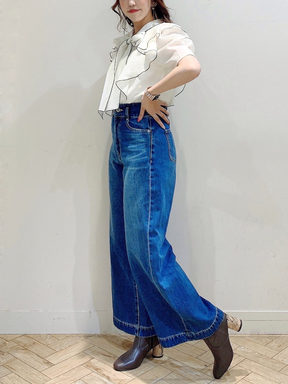 ホワイト系のシャツ/ブラウス、ブラウン系のブーツ、ブルー系のデニムパンツを着用したレディースの夏コーディネートの4枚目の写真