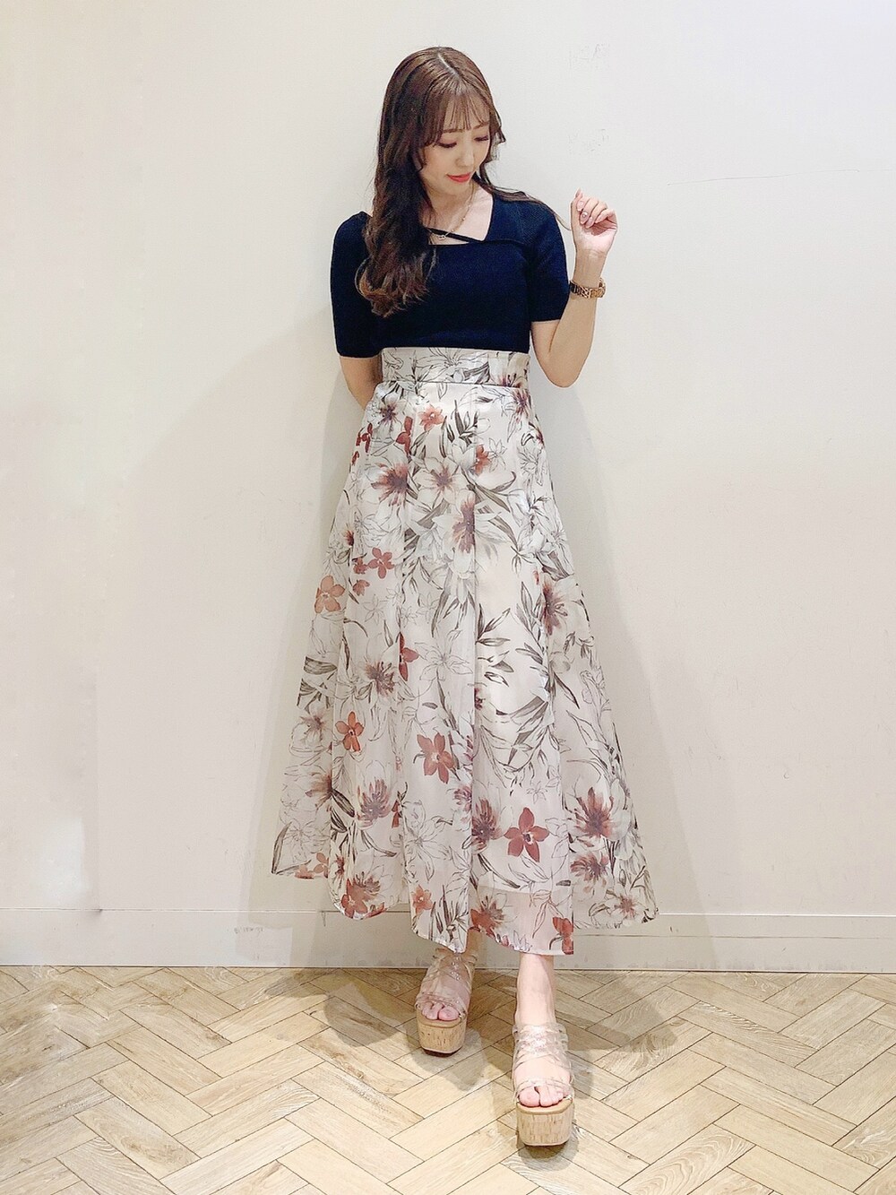 ピンク系のスカート、ブラック系のニット/セーター、その他のサンダルを着用したレディースの春コーディネートの2枚目の写真