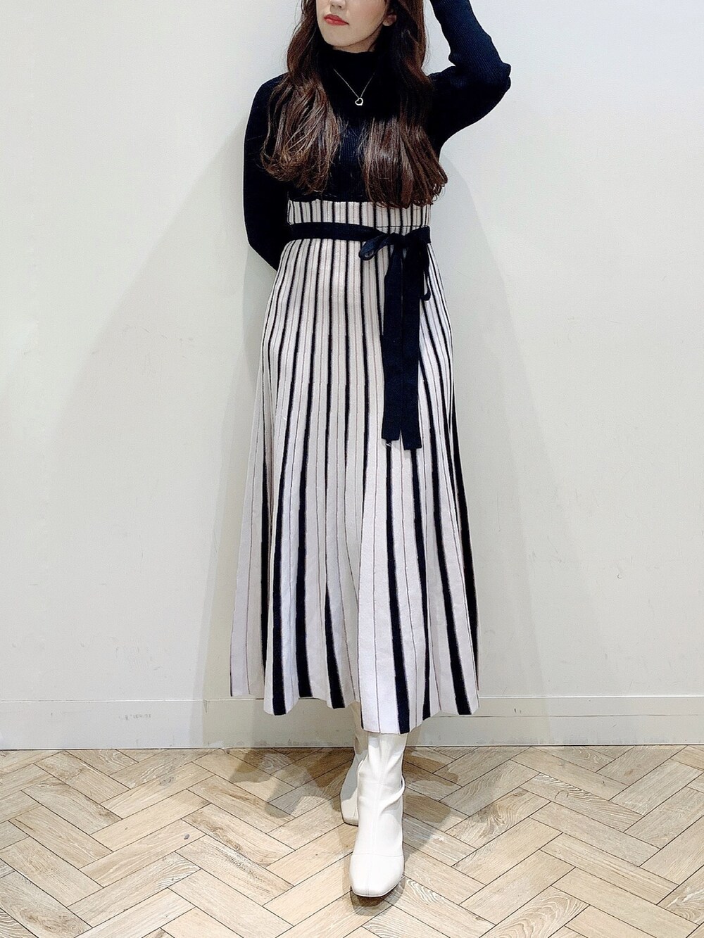 ブラック系のワンピース、ホワイト系のムートンコート、ホワイト系のブーツを着用したレディースの冬コーディネートの3枚目の写真