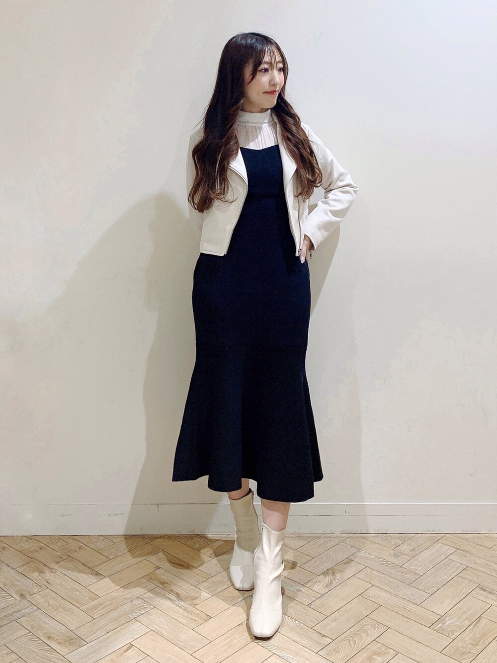 ブラック系のワンピース、ホワイト系のブーツ、ベージュ系のライダースジャケットを着用したレディースの冬コーディネートの2枚目の写真