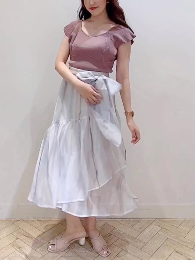 ピンク系のスカート、ブラウン系のニット/セーター、ベージュ系のサンダルを着用したレディースの夏コーディネートの3枚目の写真