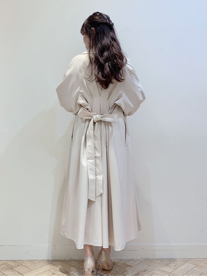 ベージュ系のパンプス、ホワイト系のスカート、ベージュ系のトレンチコートを着用したレディースの春コーディネートの7枚目の写真