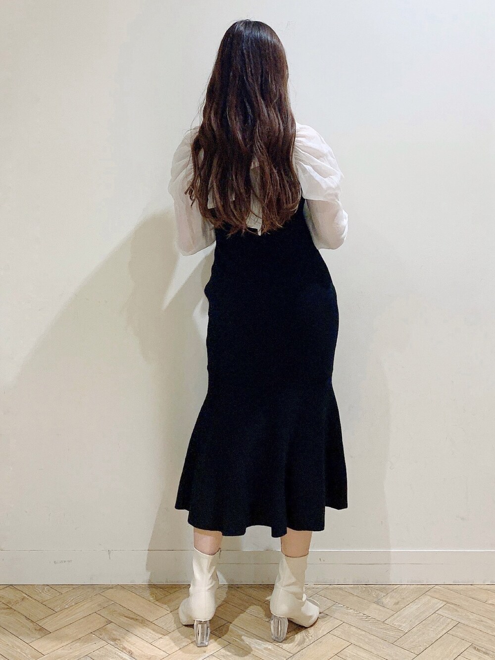 ブラック系のワンピース、ホワイト系のブーツを着用したレディースの冬コーディネートの7枚目の写真