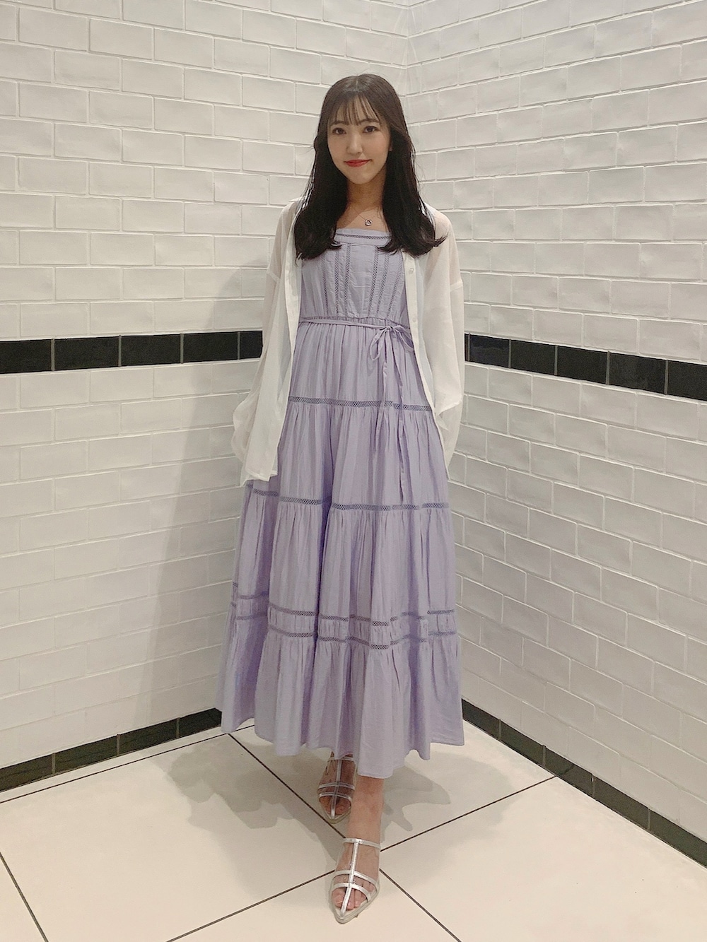 シルバー系のパンプス、パープル系のワンピース、ホワイト系のシャツ/ブラウスを着用したレディースの夏コーディネートの3枚目の写真