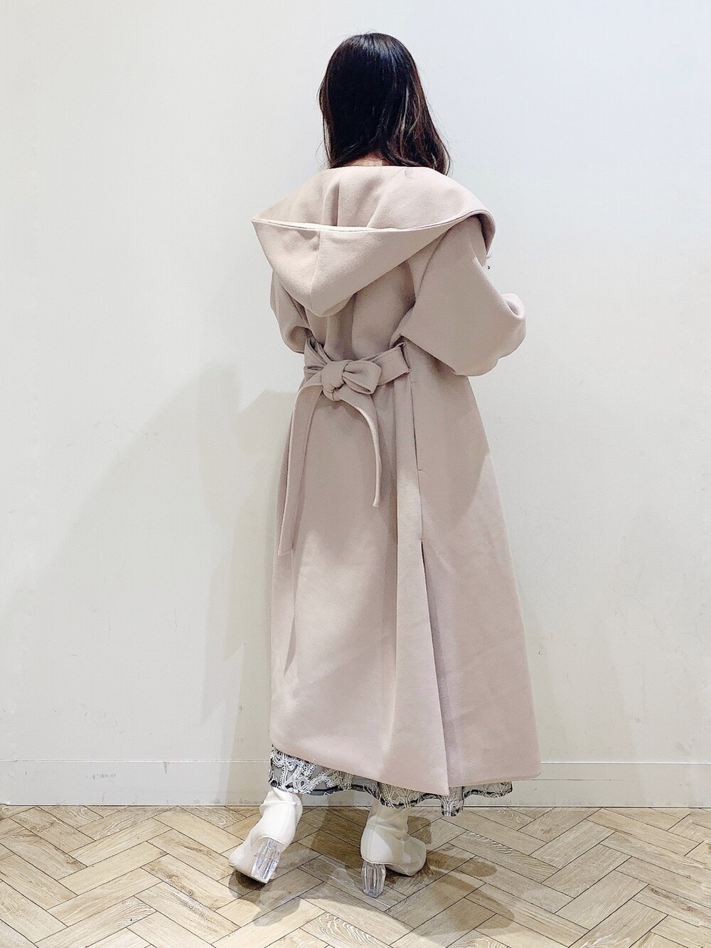 ブラック系のスカート、ホワイト系のニット/セーター、ベージュ系のチェスターコートを着用したレディースの冬コーディネートの6枚目の写真