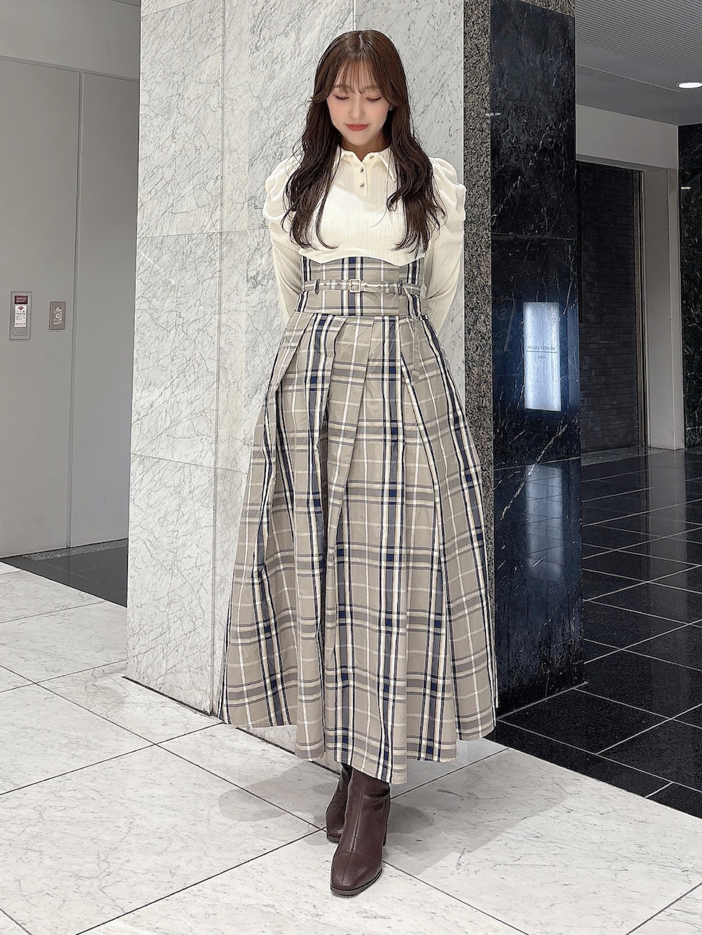 ホワイト系のワンピース、ブラウン系のブーツを着用したレディースの秋コーディネートの2枚目の写真