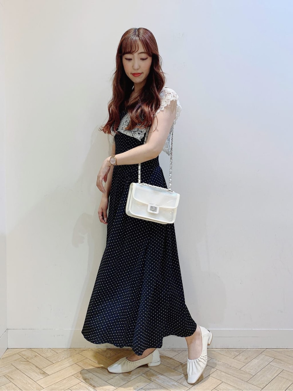 ホワイト系のパンプス、ブラック系のワンピース、ホワイト系のショルダーバッグを着用したレディースの春コーディネートの2枚目の写真
