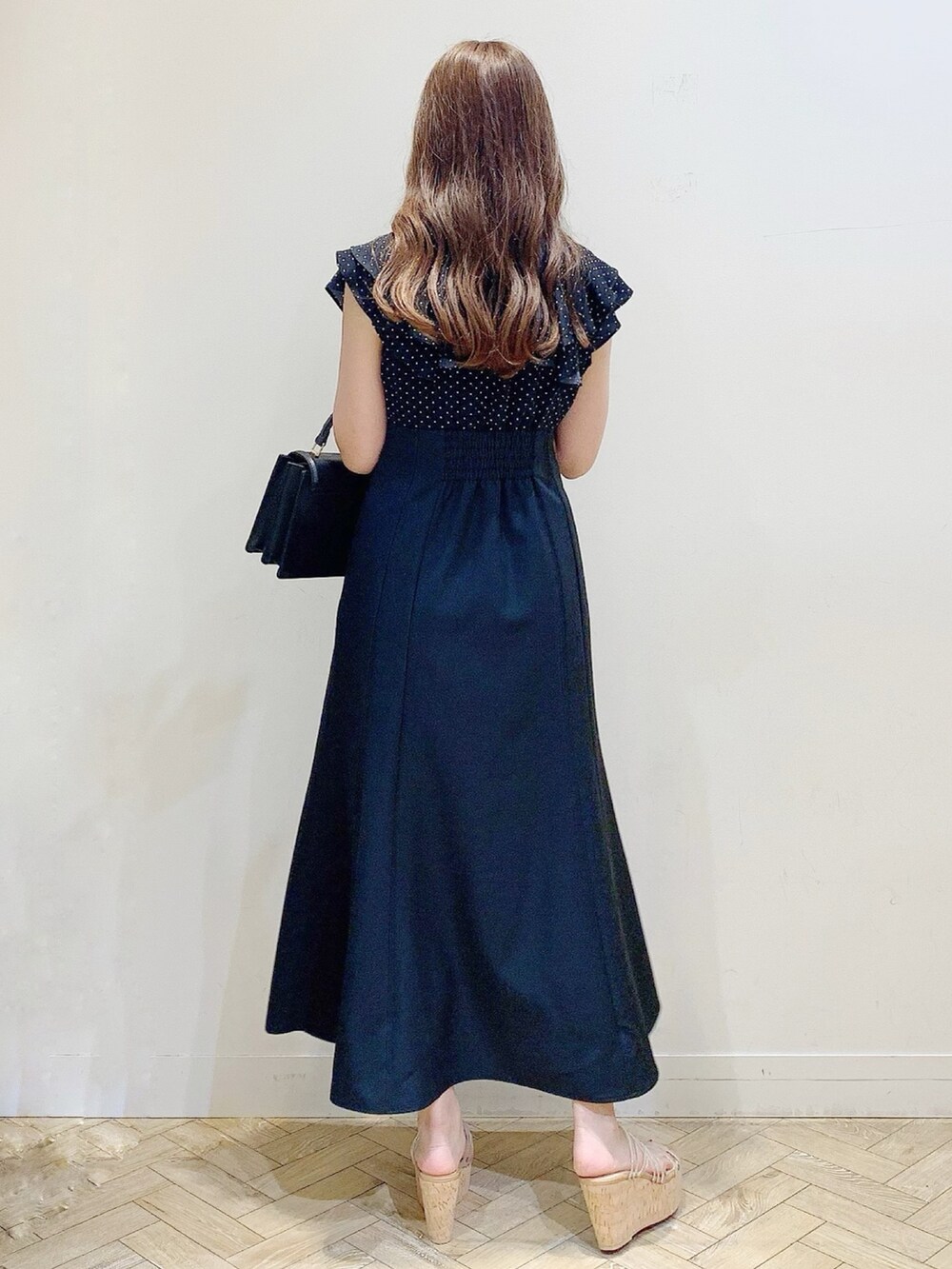 ブラック系のワンピース、その他のサンダル、ブラック系のハンドバッグを着用したレディースの春コーディネートの5枚目の写真