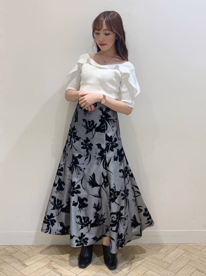 グレー系のスカート、ブラック系のサンダル、ホワイト系のニット/セーターを着用したレディースの夏コーディネートの5枚目の写真