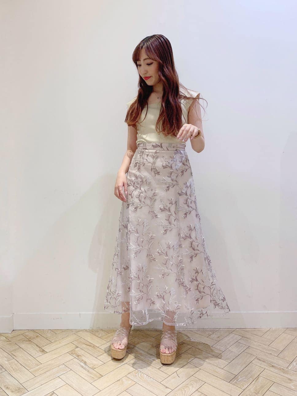 ピンク系のスカート、その他のサンダル、イエロー系のニット/セーターを着用したレディースの夏コーディネートの2枚目の写真