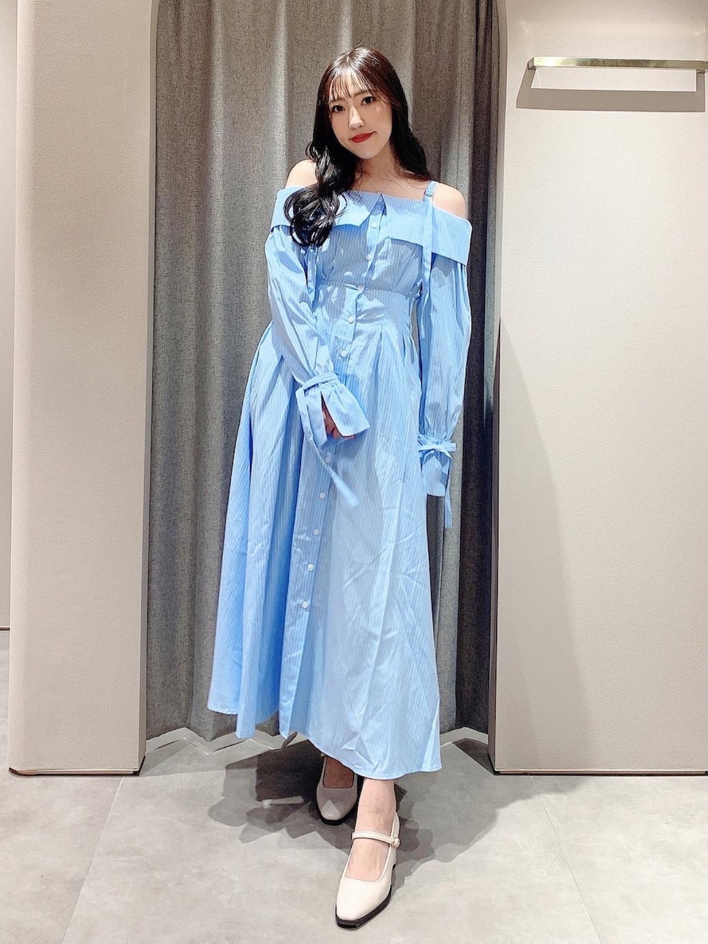 ブルー系のシャツワンピース、ホワイト系のテーラードジャケット、ホワイト系のパンプスを着用したレディースの冬コーディネートの2枚目の写真