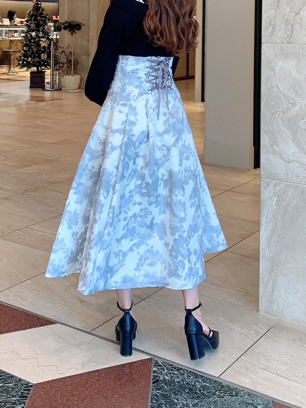 ホワイト系のスカート、ブラック系のニット/セーター、ブラック系のパンプスを着用したレディースの秋コーディネートの6枚目の写真