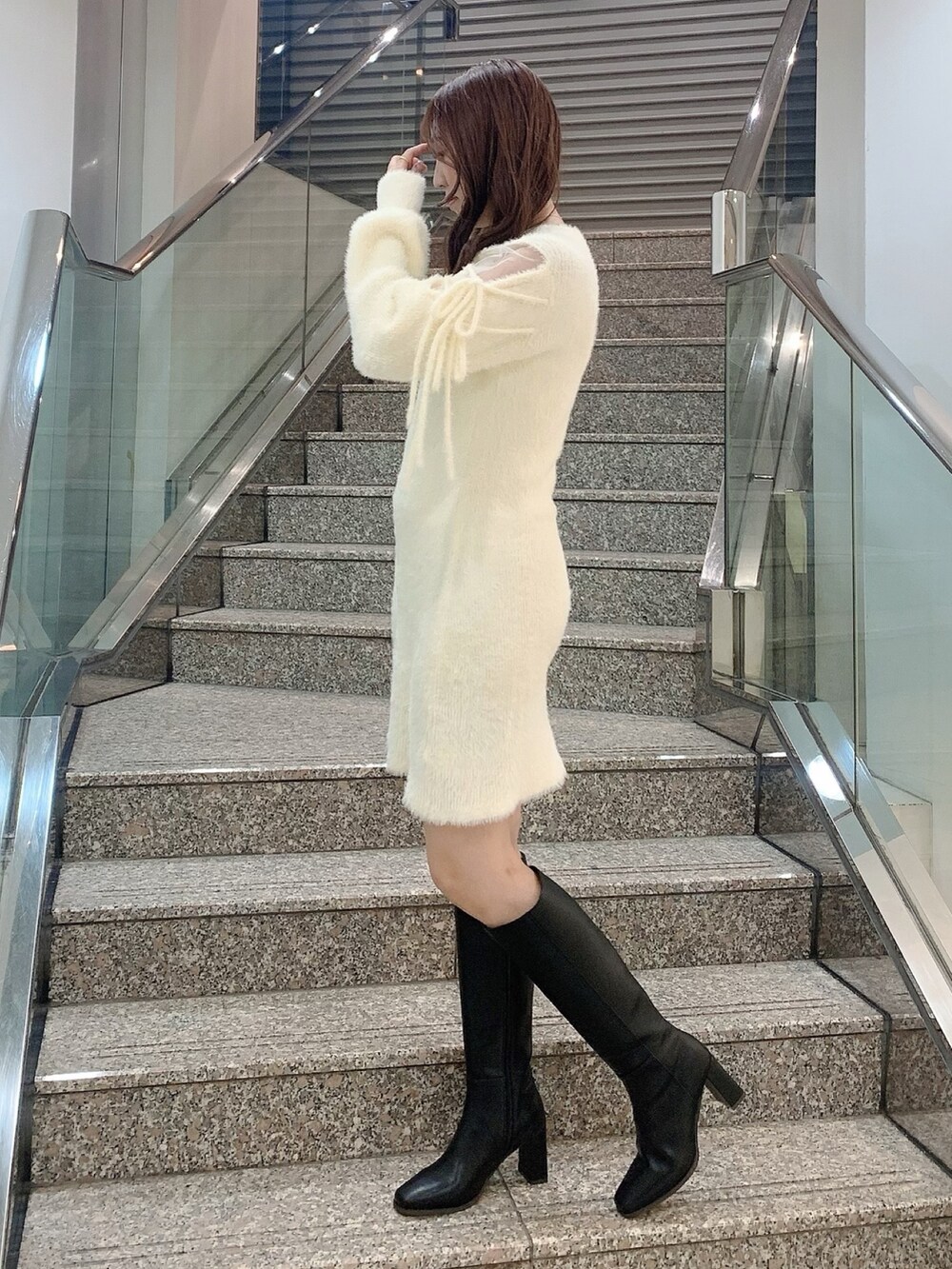 ブラック系のブーツ、ホワイト系のワンピースを着用したレディースの冬コーディネートの3枚目の写真