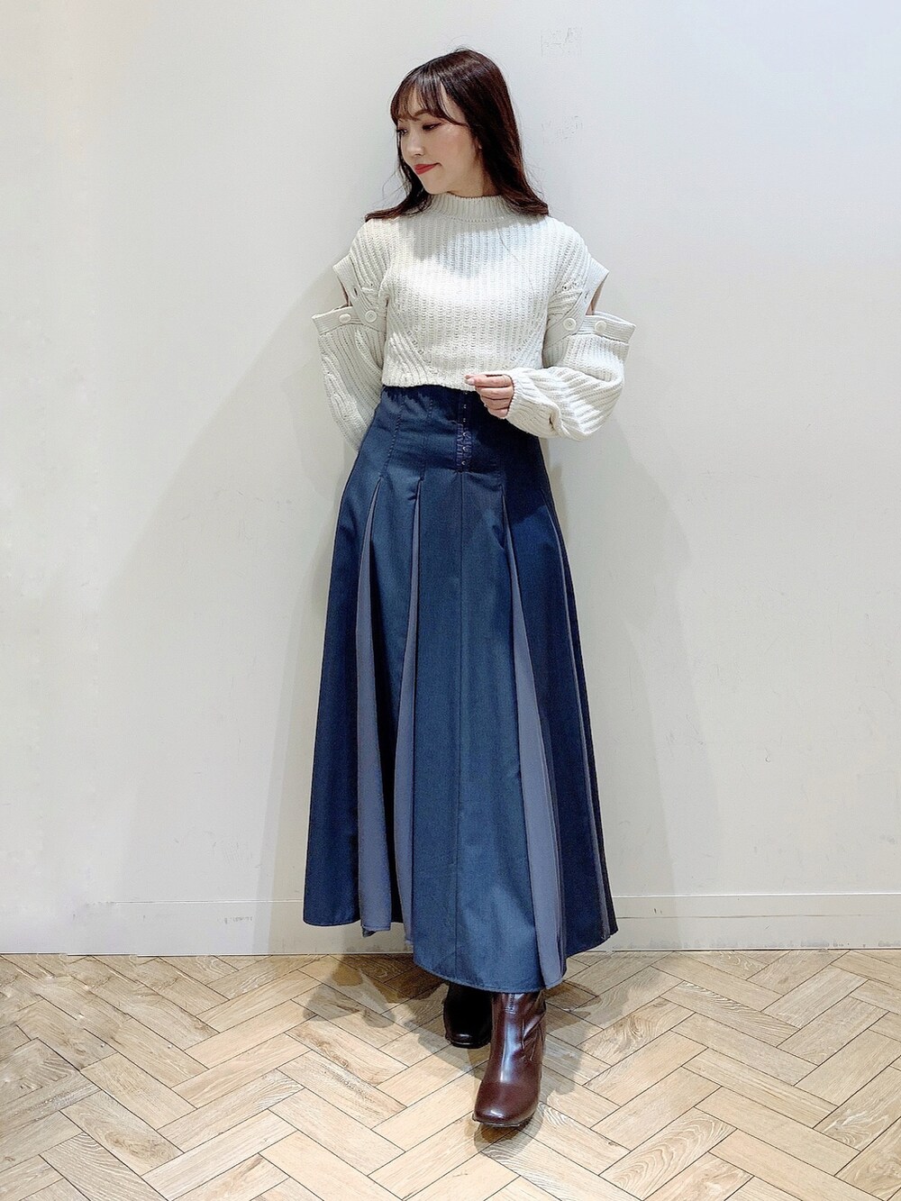 グレー系のスカート、ホワイト系のワンピース、ブラウン系のブーツを着用したレディースの冬コーディネートの3枚目の写真