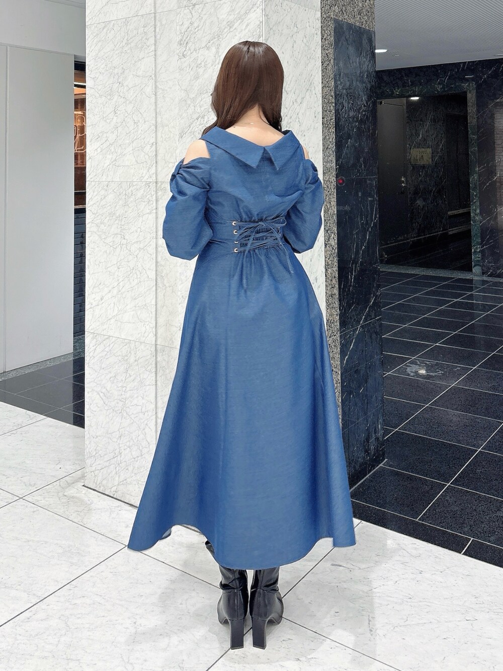 ブルー系のワンピース、ブラック系のブーツを着用したレディースの冬コーディネートの5枚目の写真