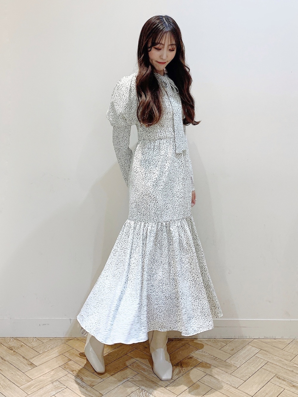 ホワイト系のワンピース、ブラウン系のダウンジャケット/コート、ホワイト系のブーツを着用したレディースの冬コーディネートの4枚目の写真