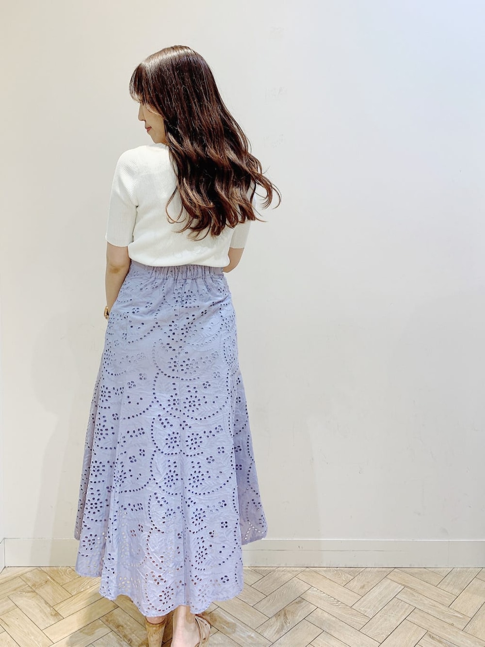 ホワイト系のニット/セーター、パープル系のスカート、ベージュ系のサンダルを着用したレディースの春コーディネートの4枚目の写真