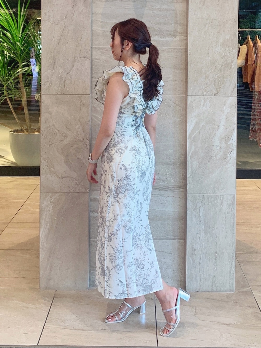 ホワイト系のワンピース、シルバー系のパンプスを着用したレディースの夏コーディネートの6枚目の写真