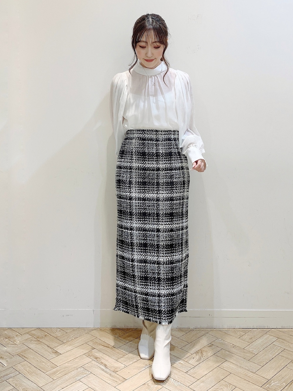 ブラック系のダウンジャケット/コート、ホワイト系のシャツ/ブラウス、ブラック系のスカートを着用したレディースの冬コーディネートの2枚目の写真