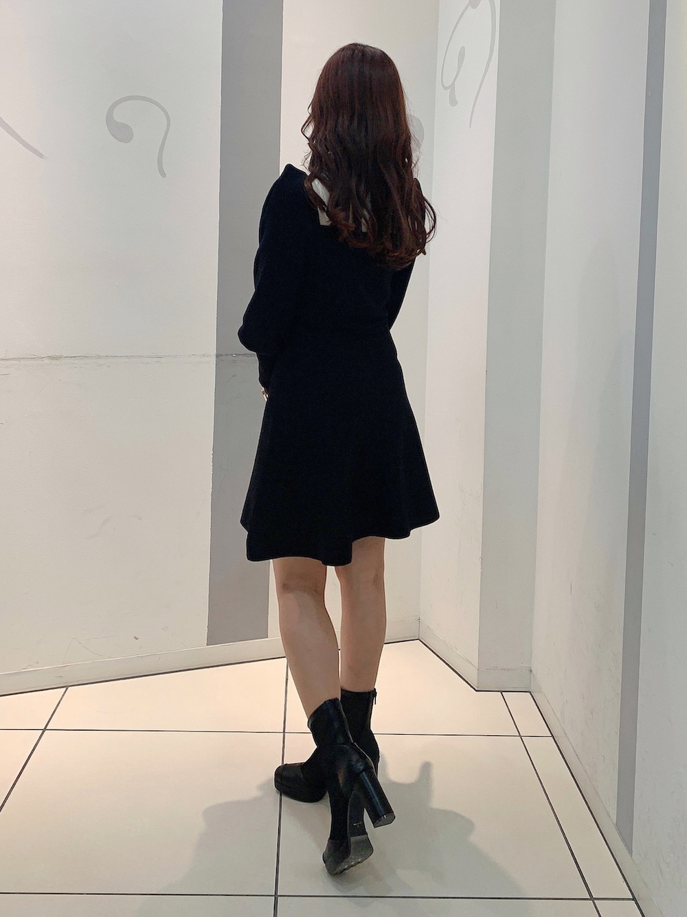 ブラック系のワンピース、ブラック系のブーツを着用したレディースの冬コーディネートの4枚目の写真