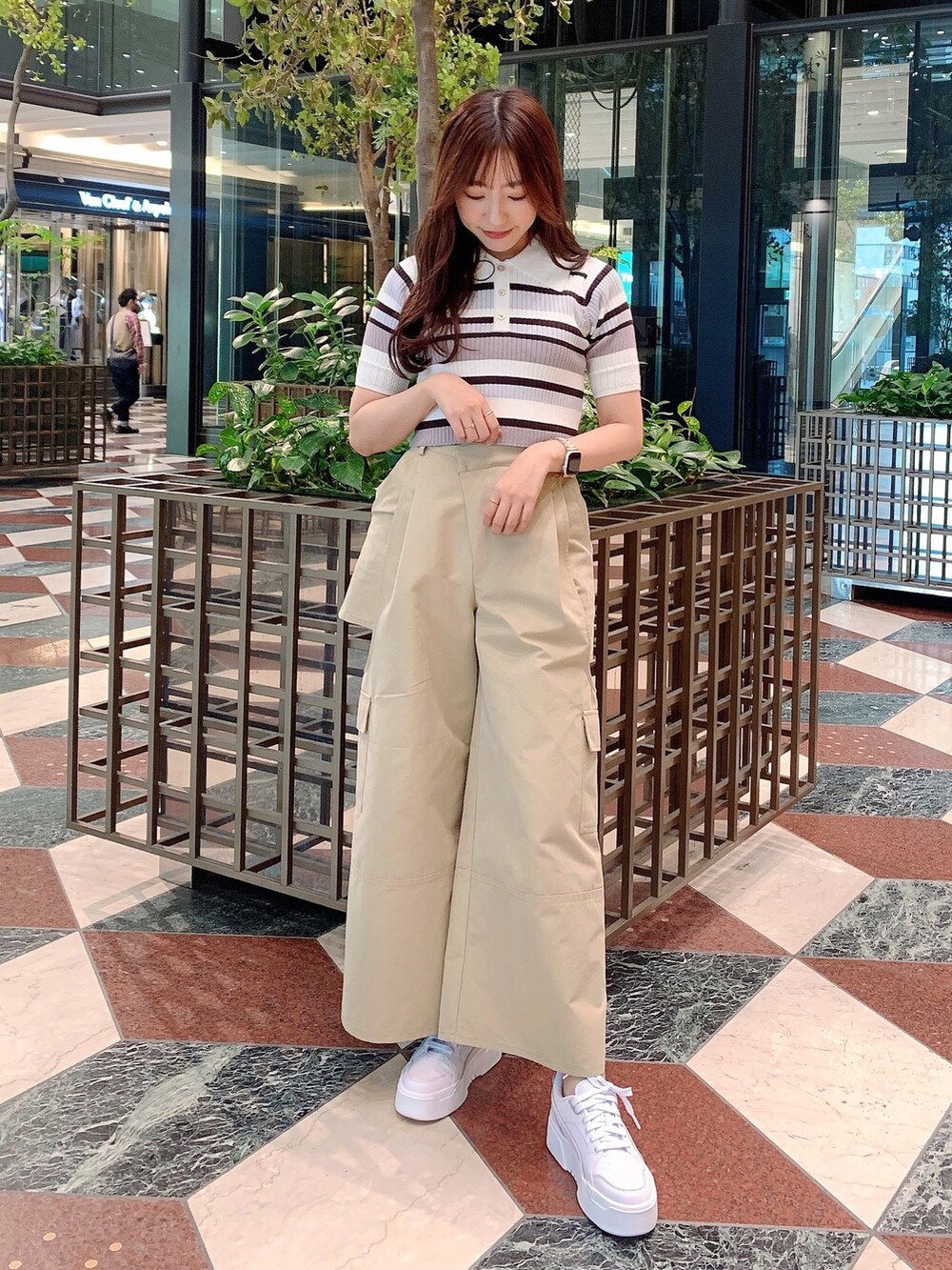 ベージュ系のチノパンツ、グレー系のニット/セーターを着用したレディースの春コーディネートの4枚目の写真