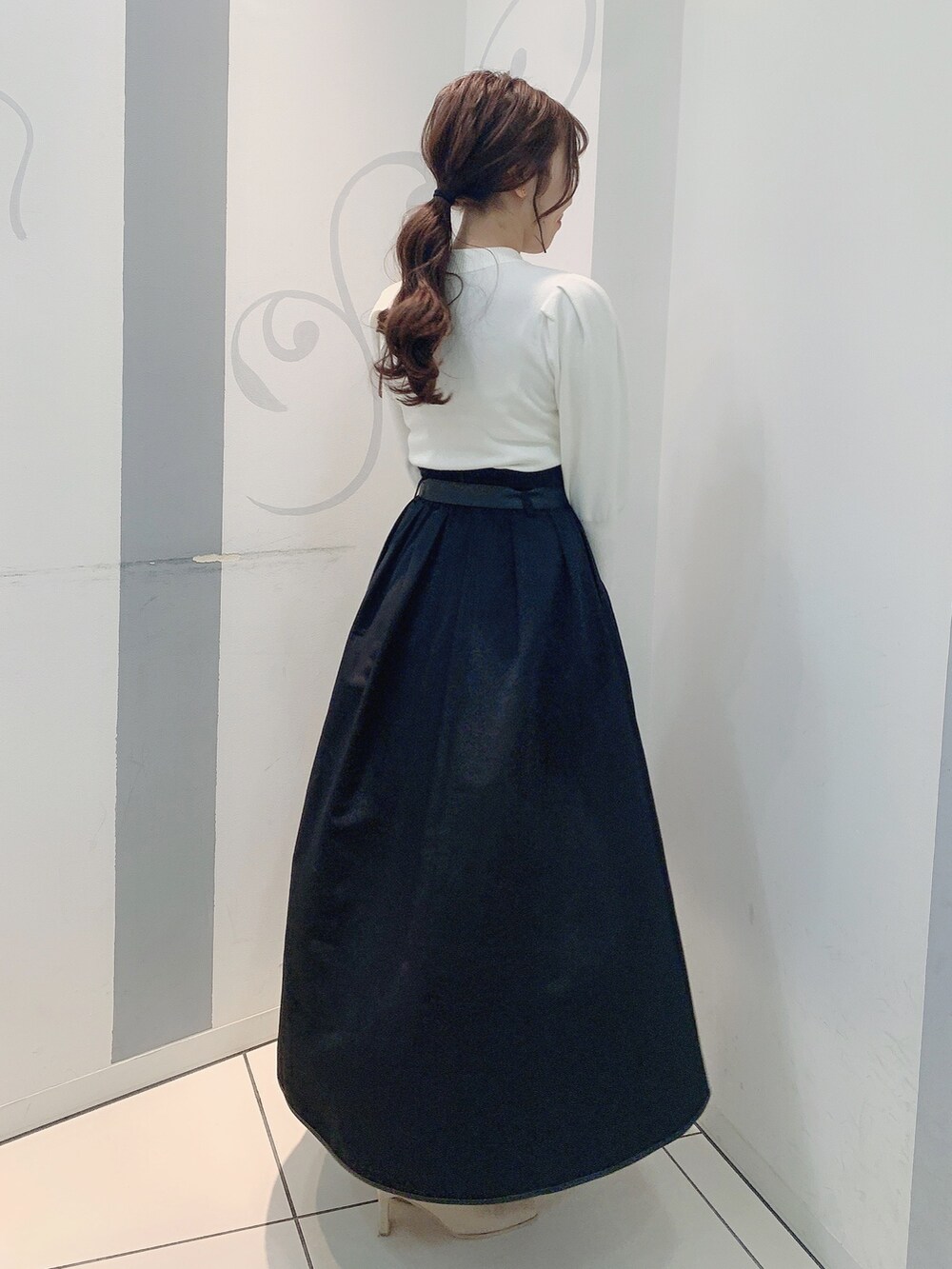 ホワイト系のブーツ、ブラック系のスカート、ホワイト系のニット/セーターを着用したレディースの秋コーディネートの5枚目の写真