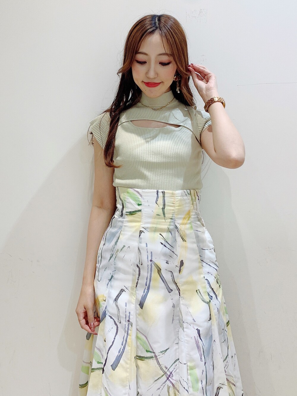 グリーン系のニット/セーター、イエロー系のスカート、ブラック系のサンダルを着用したレディースの夏コーディネートの7枚目の写真